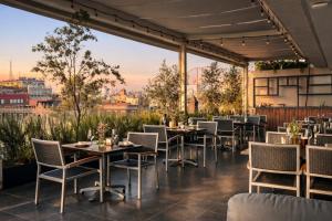 a restaurant with tables and chairs and a view of the city at Hotel Catedral in Mexico City