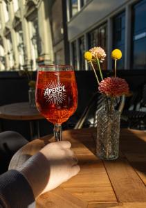 a person holding a wine glass on a table at Hotel Central Staytion in Amsterdam +53 photos