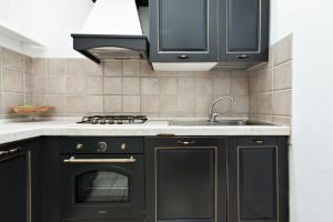 a kitchen with black cabinets and a sink at Antoglietta Suites Lecce Selection in Lecce