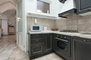 a kitchen with black cabinets and a microwave at Antoglietta Suites Lecce Selection in Lecce