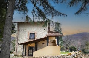 a stone house with a staircase in front of it at Casolare Brindavan Dimora Artemisia in Vaccareccia