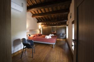 a bedroom with a red bed and two chairs at Casolare Brindavan Dimora Artemisia in Vaccareccia