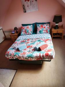 a bedroom with a bed with a colorful comforter at Studio charmant in Fouesnant