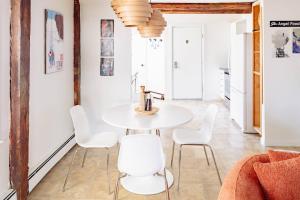 a dining room with a white table and white chairs at Epic Apartment in Downtown Stowe in Stowe