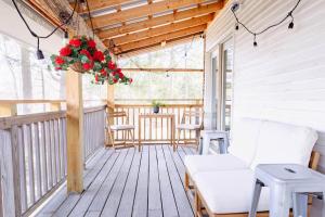 a porch with a white couch and flowers on it at Epic Apartment in Downtown Stowe in Stowe