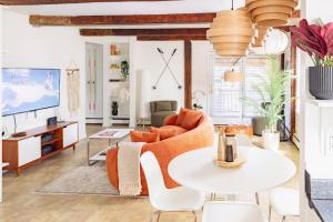 a living room with orange furniture and a white table at Epic Apartment in Downtown Stowe in Stowe