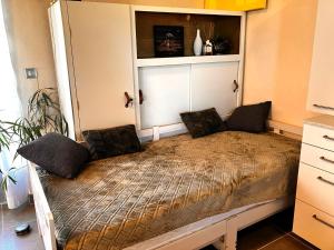 a bed in a small room with a cabinet at Périgourdine avec spa et vue in Pomport