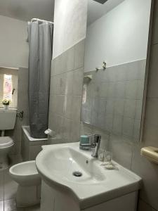 a white bathroom with a sink and a toilet at La rampata in Porretta Terme +7 photos