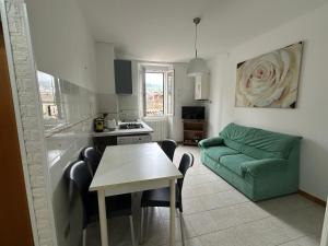 a kitchen and a living room with a green couch at La rampata in Porretta Terme