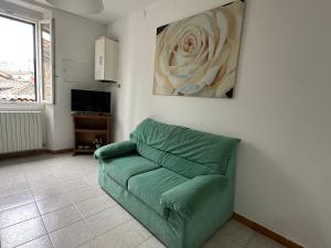 a green couch in a living room with a painting at La rampata in Porretta Terme