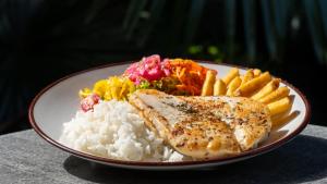 a plate of food with rice and meat and french fries at Viajero Cali Hostel & Salsa School in Cali