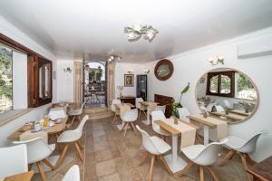 a restaurant with white chairs and tables and a mirror at Villa Palumbo in Positano +48 photos
