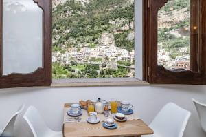 a breakfast table with a view of positano from a window at Villa Palumbo in Positano