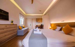 ein großes Schlafzimmer mit einem großen weißen Bett und gelben Kissen in der Unterkunft Sappho Studios in Mytilini