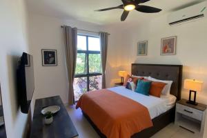 a bedroom with a bed and a ceiling fan at Stylish Condo with Rooftop Pool and Gym in Kingston