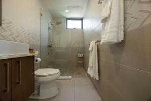 a bathroom with a toilet and a shower at Stylish Condo with Rooftop Pool and Gym in Kingston +25 photos