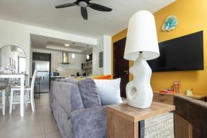 a living room with a couch and a table with a lamp at Stylish Condo with Rooftop Pool and Gym in Kingston