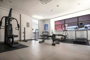 a gym with treadmills and machines in a room at Stylish Condo with Rooftop Pool and Gym in Kingston