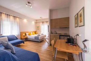 ein Wohnzimmer mit Bett, eine Küche und ein Zimmer in der Unterkunft Sappho Studios in Mytilini