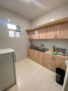 a kitchen with wooden cabinets and a sink at Golden New Alareen-جولدن العرين أبها in Abha