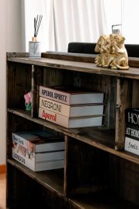 a pile of books on a wooden shelf at Ferien Wohnung mit Seeblick in Romanshorn