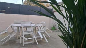 a white table and chairs and a plant at Maison cosy esprit campagne in Luçon