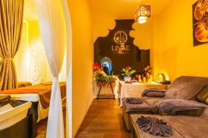 a room with a bed and a couch and a table at La Cheminee Boutique Apartment in Phú Quốc