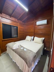 a bedroom with a bed in a room with a window at Cerrado da Canastra Chalé com Banheira in São Roque de Minas
