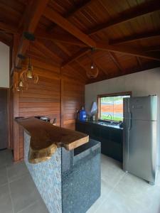 a kitchen with a counter and a refrigerator at Cerrado da Canastra Chalé com Banheira in São Roque de Minas