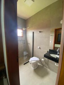 a bathroom with a toilet and a sink at Cerrado da Canastra Chalé com Banheira in São Roque de Minas +15 photos
