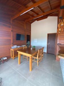 a dining room with a wooden table and chairs at Cerrado da Canastra Chalé com Banheira in São Roque de Minas