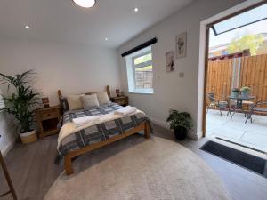 a bedroom with a bed and a balcony with a table at Entire Apartment Bright & Spacious with Private Garden Near Victoria Park in London