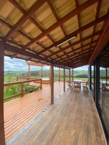 a large wooden deck with tables and chairs on it at Cerrado da Canastra Chalé com Banheira in São Roque de Minas