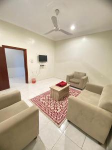 a living room with two couches and a tv at Golden New Alareen-جولدن العرين أبها in Abha