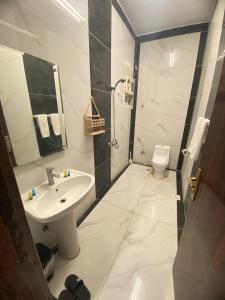 a white bathroom with a sink and a toilet at Golden New Alareen-جولدن العرين أبها in Abha +16 photos