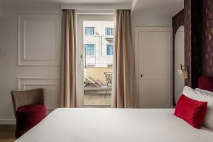 a bedroom with a large white bed and a window at BYPILLOW Callao in Madrid