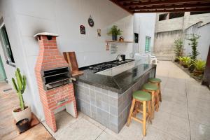 a kitchen with a brick stove and stools in a kitchen at Apartamento 2 Vargem Grande RJ in Rio de Janeiro