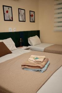 a hotel room with two beds with towels on them at Apartamento 2 Vargem Grande RJ in Rio de Janeiro +15 photos