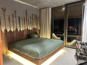 a bedroom with a bed with a wooden headboard at Chum Home - 02 in Danang
