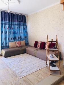 a couch in a living room with a blue curtain at Dar Mariem Douz in Douz