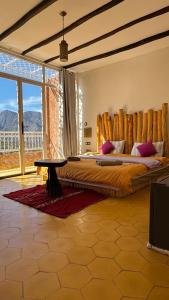 a bedroom with a large bed with a wooden headboard at KASBAH LA DAME BIJA in Ouirgane +73 photos