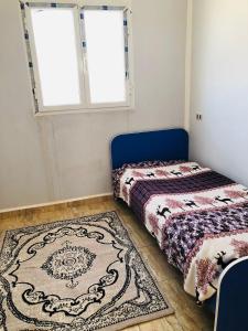 a bedroom with two beds and a rug at Dar Mariem Douz in Douz +18 photos