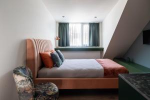 a small bedroom with a bed and a chair at Core - Corporate Studios by Weeklyflex in Strassen