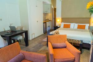 a hotel room with a bed and two chairs and a desk at Galileo Boutique Hotel in San Carlos de Bariloche