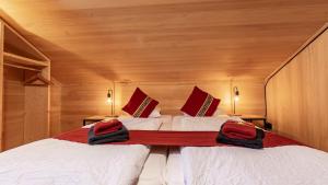 a bedroom with two beds with red pillows at Naturfreunde Hostel Grindelwald in Grindelwald +60 photos
