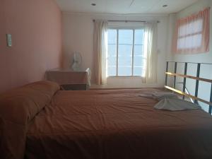 a bedroom with a large bed with a window at La casa de Napoli in Trelew