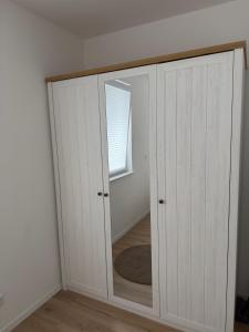 a white cabinet with a mirror in a room at Bauna Suites & Apartments in Baunatal