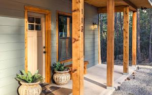 a porch of a house with two vases on it at T-Post - A Beautiful New-Build with Treetop Deck in Ruidoso