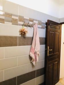 a bathroom with a towel hanging on a wall at Dar Mariem Douz in Douz