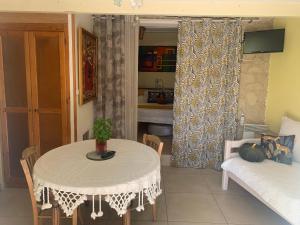a living room with a table and a couch at DEPENDANCE PRIVEE - HALTE ROUTE in Le Thor